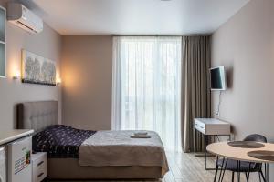 a hotel room with a bed and a table and a window at Aura Home in Dnipro