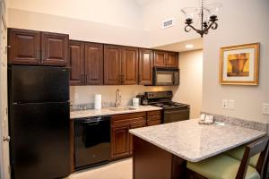 a kitchen with wooden cabinets and a black refrigerator at Annabell Gardens in Lincoln