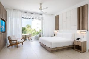 Habitación de hotel con cama y balcón en Wymara Resort & Villas, en Grace Bay