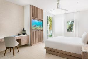 1 dormitorio con cama, escritorio y silla en Wymara Resort & Villas, en Grace Bay