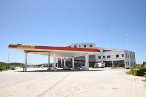 a gas station with a large building in the background at Fjortes Palace in Vlorë