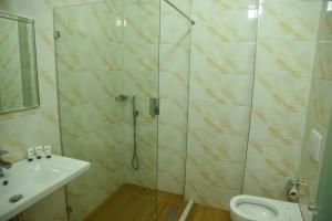 a bathroom with a shower with a sink and a toilet at Fjortes Palace in Vlorë +53 photos
