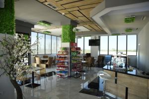 a lobby with a store with chairs and a table at Fjortes Palace in Vlorë