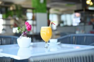 a glass of orange juice sitting on a table at Fjortes Palace in Vlorë