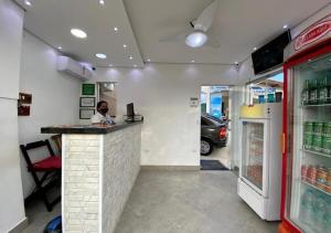 un homme assis au comptoir d'un fast-food dans l'établissement Pousada Mar Suites, à Ubatuba