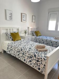 two beds in a white room withskirts at UIM Mediterraneo Segorbe 1 Wifi in Puerto de Sagunto