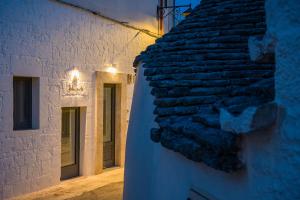 a building with a stone wall next to a street at Petra Suite in Alberobello