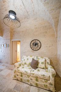 a living room with a couch in a stone wall at Petra Suite in Alberobello