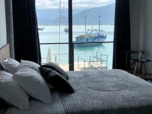 a bedroom with a large window with a boat in the water at 1819 Marine Hotel in Ubatuba