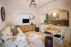ein Wohnzimmer mit Sofa und Tisch in der Unterkunft Petra Suite in Alberobello