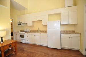 a kitchen with white cabinets and a white refrigerator at Waterview On The Bay in Wiarton