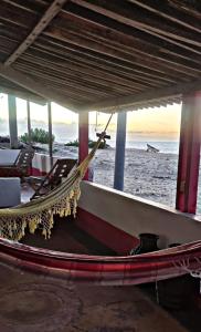 a hammock on a beach with a view of the ocean at Pousada Dalva in Galinhos