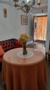 una sala de estar con una mesa con un jarrón de flores. en Casa Rocio, en Capileira