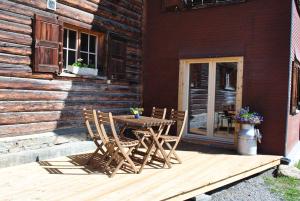 una mesa de madera y sillas en una terraza de madera en Hof Surri, 