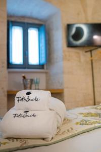 a stack of towels sitting on top of a bed at Petra Suite in Alberobello