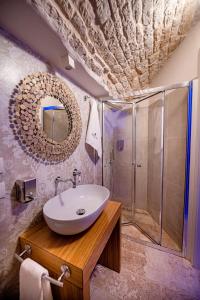 ein Bad mit einem Waschbecken und einer Dusche in der Unterkunft Petra Suite in Alberobello