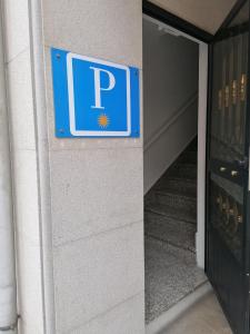 um sinal de estacionamento na lateral de um edifício em Cuatro Caminos em Sarria