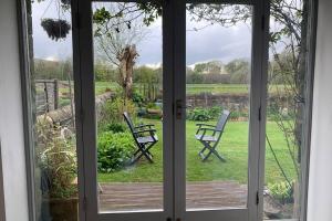 een open deur met twee stoelen in de tuin bij Spacious with spectacular views and private garden in Buxton