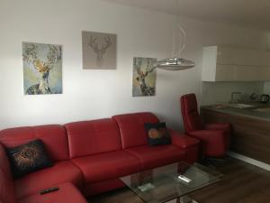 a living room with a red couch and a table at Foreta in Bratislava +9 photos