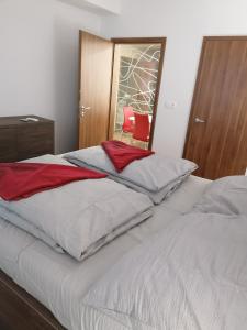 布拉提斯拉瓦的住宿－Foreta，一间卧室配有两张床和红色椅子