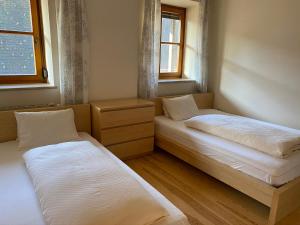 twee bedden in een kleine kamer met twee ramen bij VIII Panorama-Ferienwohnung Petzenblick in Sankt Michael ob Bleiburg