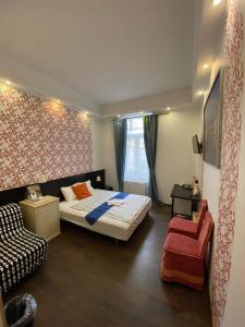 sypialnia z łóżkiem i krzesłem w obiekcie Centerpoint Panzio w Budapeszcie