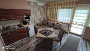 a kitchen and a living room with a table and a couch at Apartman Edit in Harkány +20 photos