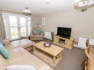 a living room with a couch and a tv at Harbour View in Cemaes Bay
