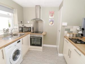 a kitchen with a sink and a washing machine at Harbour View in Cemaes Bay