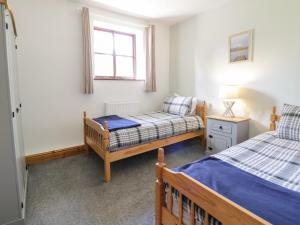 1 dormitorio con 2 camas y ventana en Cyffdy Cottage - Arenig en Bala