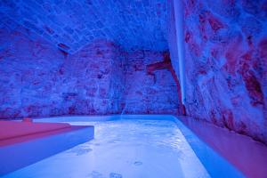 ein Zimmer mit einer Badewanne in einer Ziegelwand in der Unterkunft Petra Suite in Alberobello