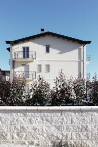 un edificio blanco detrás de una pared de piedra en ReGenzio, en Colledara