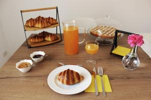 una mesa con un plato de cruasanes y zumo de naranja en ReGenzio, en Colledara