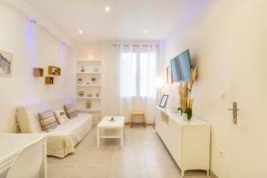 een witte woonkamer met een bed en een tafel bij Appartement "Les pieds dans l'eau" 1 chambre Parking JO in Marseille
