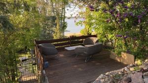 eine Holzterrasse mit 2 Stühlen und einem Tisch in der Unterkunft Ferienhaus in Arendsee mit direkter Seenähe in Arendsee