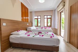 two beds in a bedroom with pink flowers on them at Castello Hotel & Aparts in Kemer +64 photos