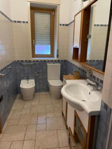uma casa de banho com um WC, um lavatório e um WC. em Le nuove porte di Taormina em Taormina