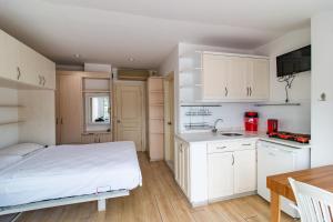 a bedroom with a bed and a kitchen with white cabinets at Castello Hotel & Aparts in Kemer