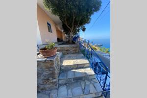 a staircase leading up to a house with a view of the ocean at Πέτρινη αυλή, Αρμενιστης Ικαρια in Armenistis