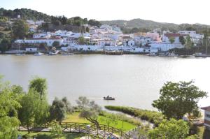 a small boat on the water in front of a town at La Tinajita in Sanlúcar de Guadiana