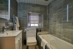 ein Badezimmer mit einer Badewanne, einem WC und einem Waschbecken in der Unterkunft Golspie Inn in Backies