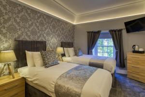 a bedroom with two beds and a television in it at Golspie Inn in Backies