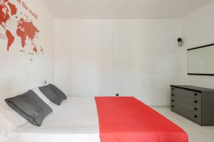 1 dormitorio con cama blanca y manta roja en Casa Lu Maccu - Sea View Apartment, en Cannigione