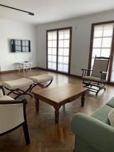 a living room with a wooden coffee table and chairs at Balcón de los Campanarios in Salta