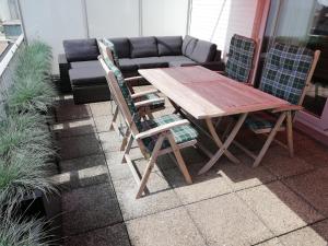 una mesa y sillas en un patio con sofá en Appartement, residentie Syci, en Koksijde