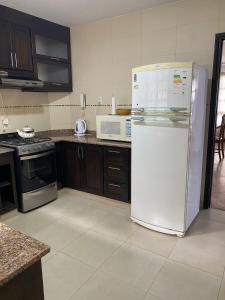 a kitchen with a white refrigerator and a microwave at Balcón de los Campanarios in Salta