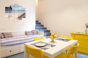 a dining room with a table and yellow chairs at Il Nido di Raito in Vietri sul Mare
