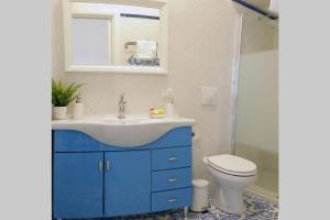 a bathroom with a blue sink and a toilet at Il Nido di Raito in Vietri sul Mare +27 photos