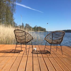 two chairs sitting on a dock next to the water at Wikno 3 Woda i Las in Wikno