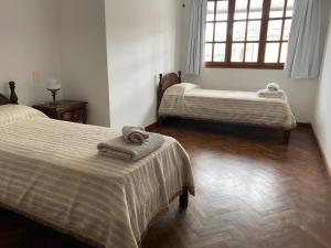 a room with two beds and a window at Balcón de los Campanarios in Salta